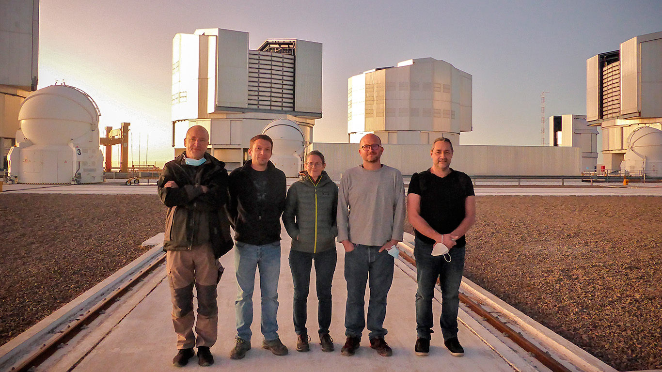 Group photo at Paranal Observatory featuring five people standing outdoors. From left to right: Pierre Bourget from the European Southern Observatory, William Guerin from Université Côte d'Azur, Mathilde Hugbart from Université Côte d'Azur, Nicolas Schuhler from the European Southern Observatory, and Jean-Pierre Rivet from the Observatoire de la Côte d’Azur.
