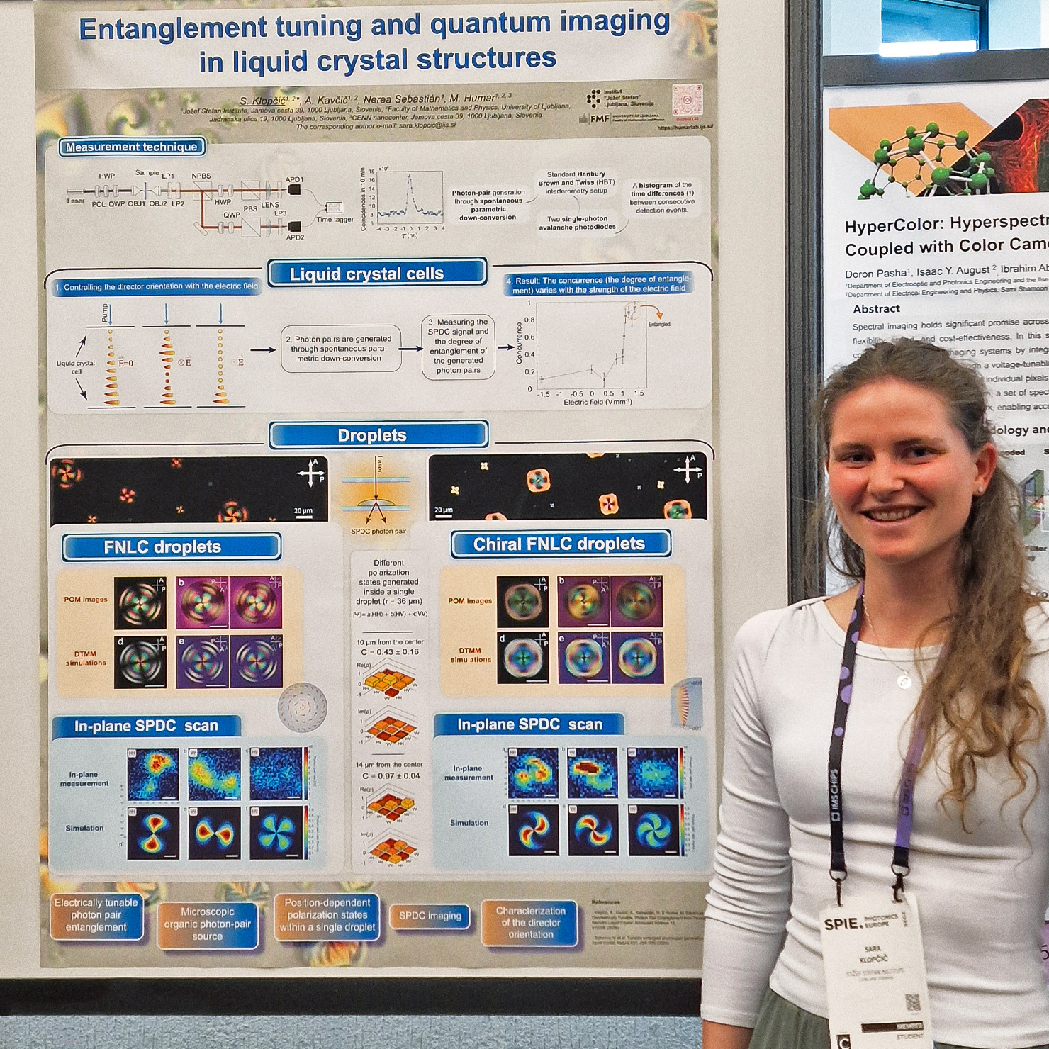 Sara Klopčič standing next to her poster at SPIE Photonics Europe, presenting research on quantum entanglement tuning and imaging in liquid crystal structures using a Time Tagger Ultra  from Swabian Instruments.